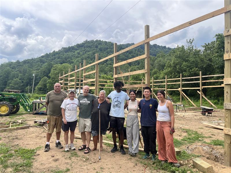 Charles and Kathryn of Lend-A-Hand with Josh Bills of Mountain Association and a team from Appalachia-Science in the Public Interest in June 2026. They are standing in front of the new food pantry building that is being constructed