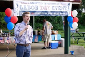 Man stands in front of balloons at an event in central appalachia. It's part of a celebration of coalfield development