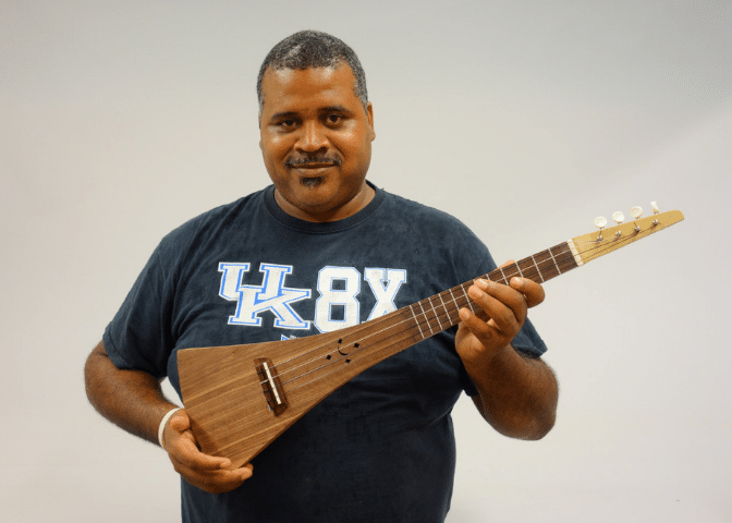 A culture of recovery participant holds an instrument they built at the Appalachian Artisan Center in Knott county.