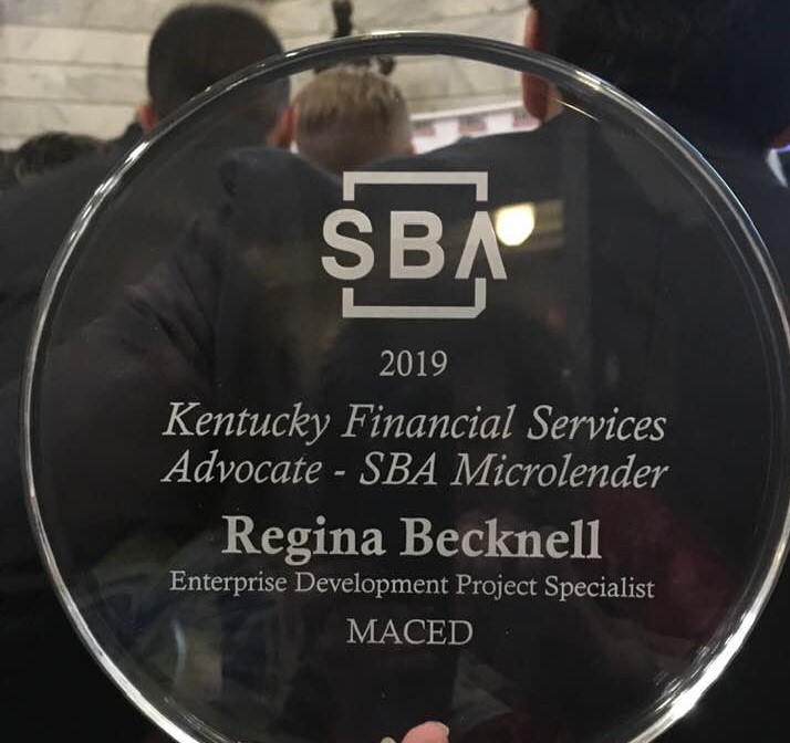 A glass award received by an employee at the mountain association for being a kentucky financial services SBA microlender