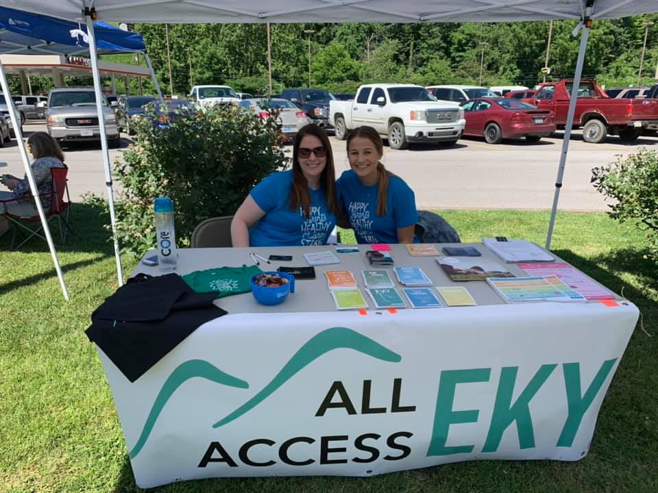 Two people sit at an All Access EKY tabling event at Mountain Comprehensive Health Care health fair in eastern kentucky.