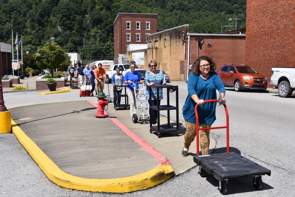 A group of people push carts in downtown HArlan Kentucky as a way to test sidewalk accessibility in the eastern kentucky town.