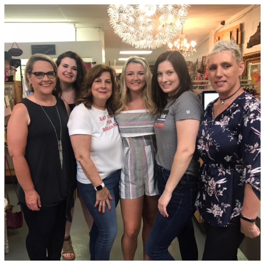 Six people stand inside Annie's Frugal Finery, a consignment store in letcher county that invests in its employees and plays a fair wage.