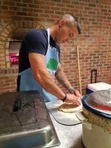 a man cuts pizza inside blacksheep brick oven and bakery in neon, kentucky.