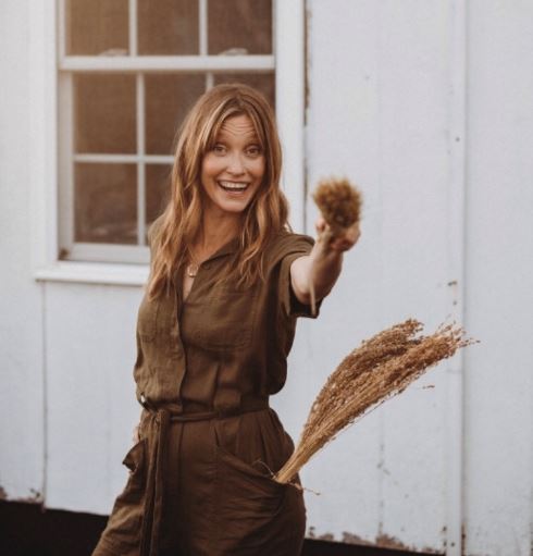 Cynthia main, a business owner stands with broom weaving in her hand. She makes brooms in berea kentucky in madison county