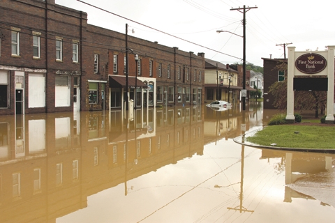 a flooded street in Olive Hill Kentucky shows a car and buildings under water