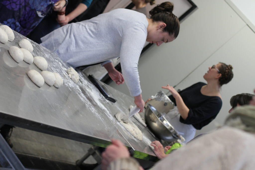 A group of people stand around a table during a baking class in eastern kentucky. The class was taught by a whitesburg resident