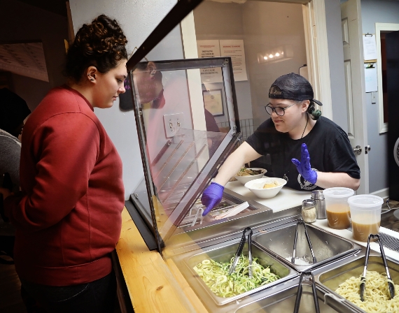 woman serving cafeteria-style food