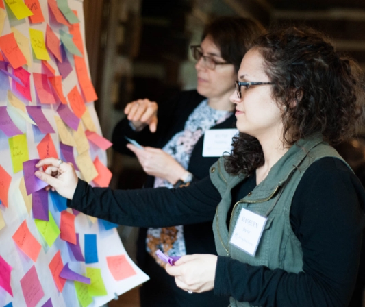 women using sticky notes to brainstorm