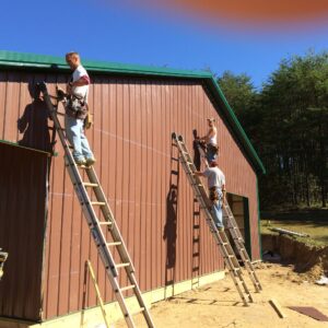 Men on ladders building TG Designs woodshop in Stanton ky.