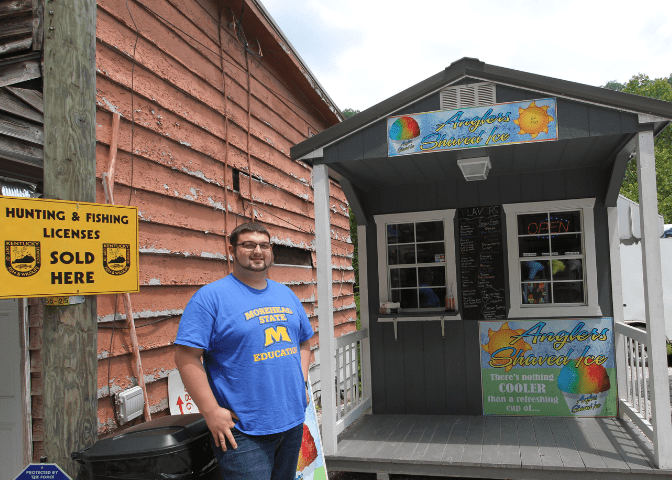 Business owner stands outside the bait shop and the shaved ice shop. The shops are popular stops for vacationers to jenny wiley lake