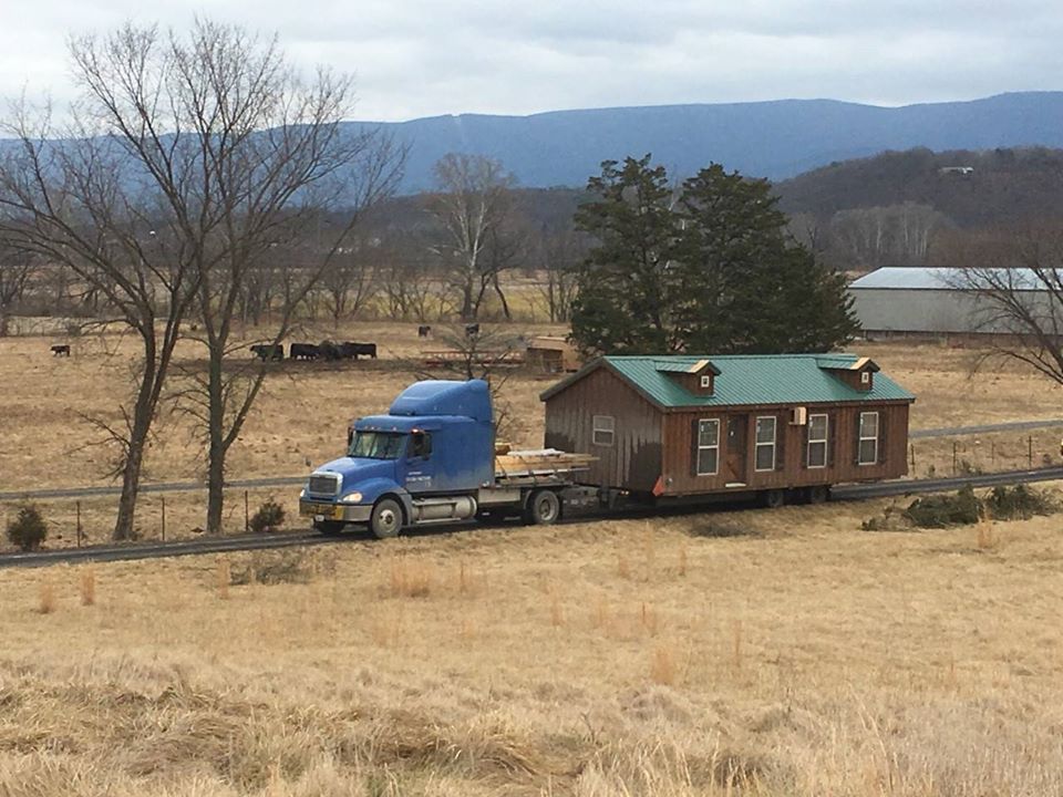 A truck pulls a cabin from Munfordville, Kentucky, where an Amish community builds custom cabins for sale at the Amish Cabin Company
