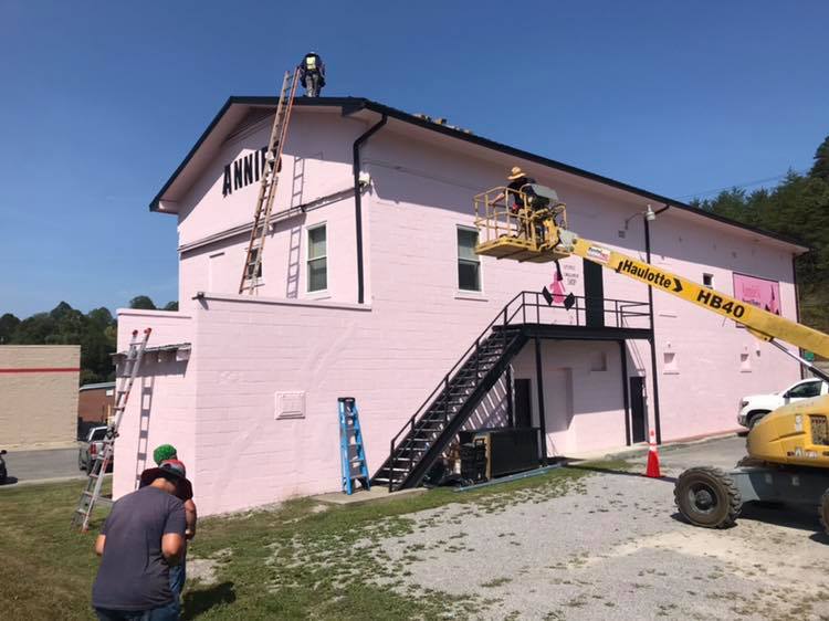 A lift takes solar panels on top of the pink building at Annie's Frugal Finery in Whitesburg. The Eastern Kentucky business is also energy efficient