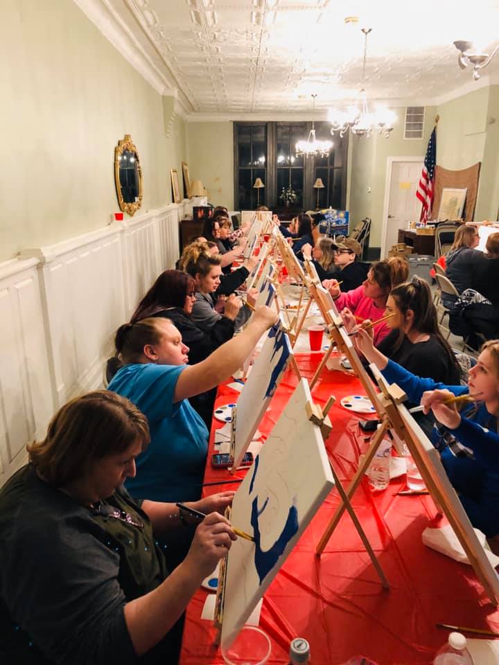 Multiple women participate in a painting class in Salyersville, kentucky.