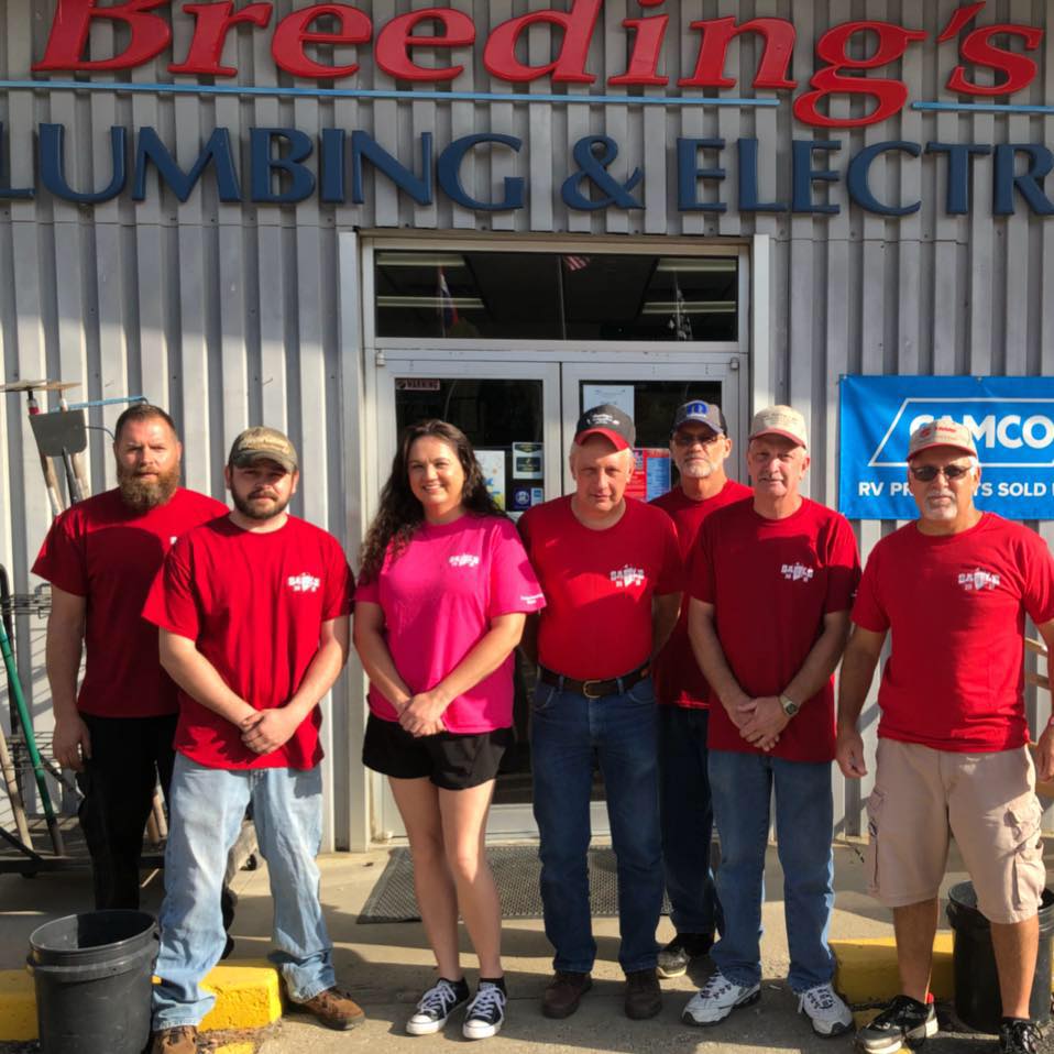 The staff at Breeding's Plumbing and Electric in Letcher County, Kentucky, stand in front of the store, which is now solar powered.