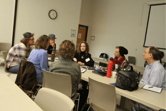 Several people sit around a table during a training in hazard kentucky on worker cooperative models. Appalachians are retiring.