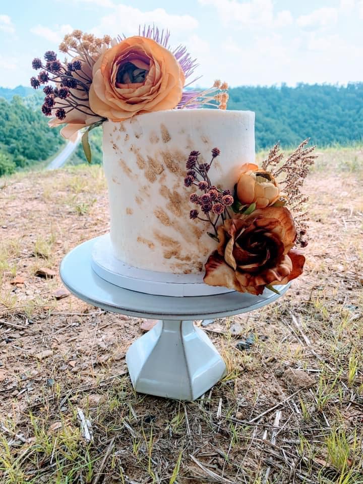 A wedding cake with flowers decorating it in floyd county, kentucky. 