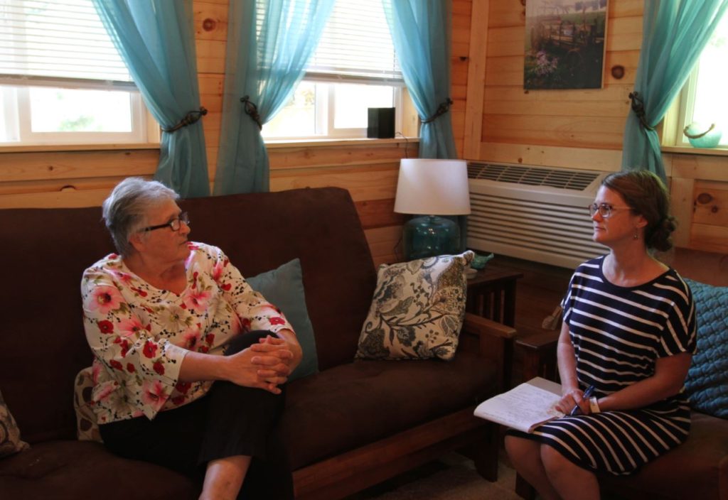 Two women sit on couches inside the Manchester Kentucky airbnb. The airbnb helps build tourism in eastern kentucky