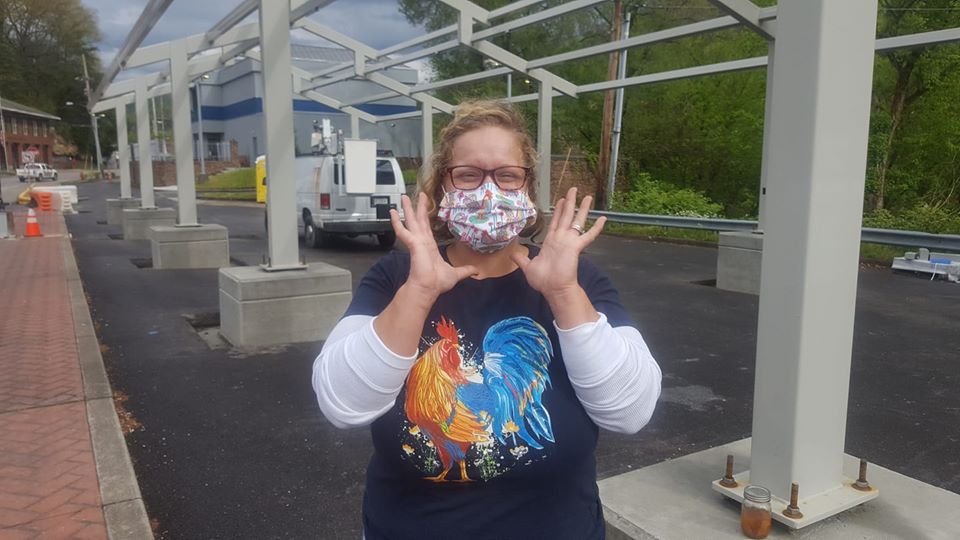 A woman in mask stands in front of the he Perry County Farmers Market pavilion currently under construction in Hazard, Kentucky.