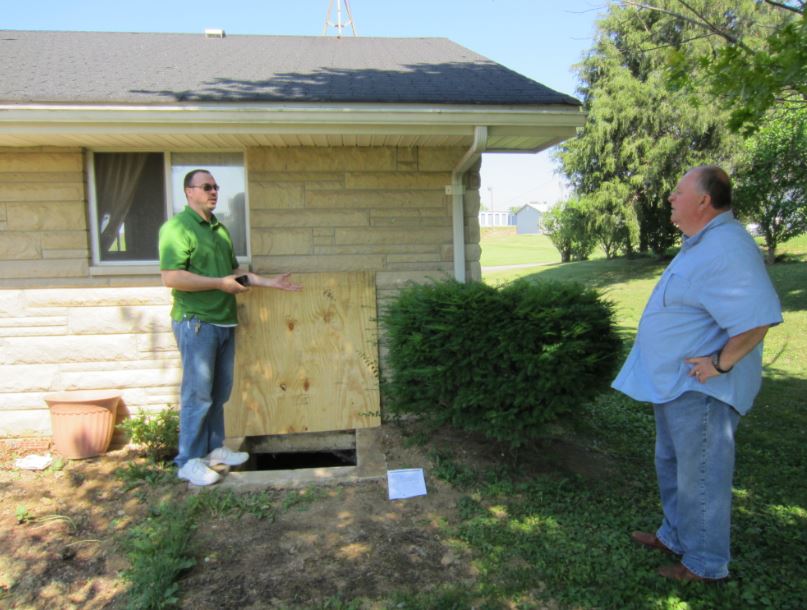 Two men stand during an energy efficiency assessment of a home in Eastern Kentucky.