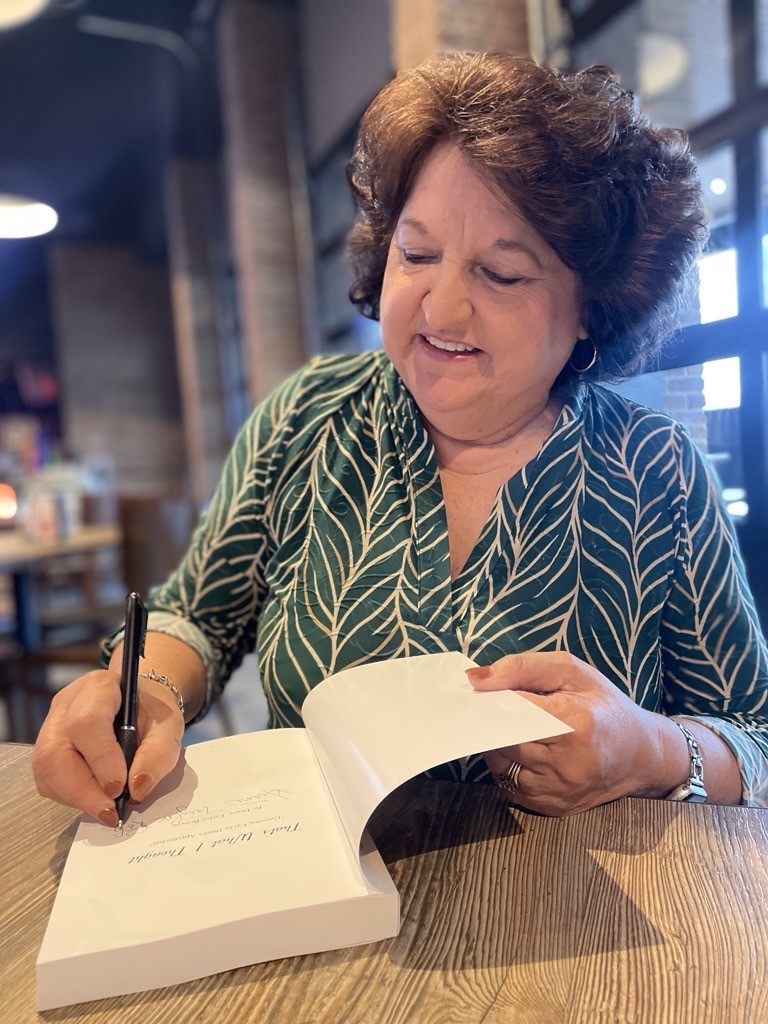 Diane Taylor Roberts signs a book at a book signing event