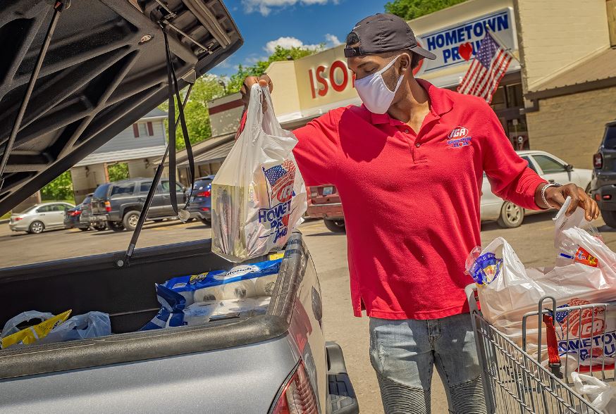 Employee wears masks while loading bagged groceries into the back of a truck during covid-19 in eastern kentucky.