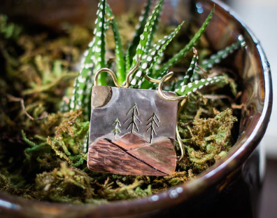 One of Jill's handmade pendants resting on a succulent