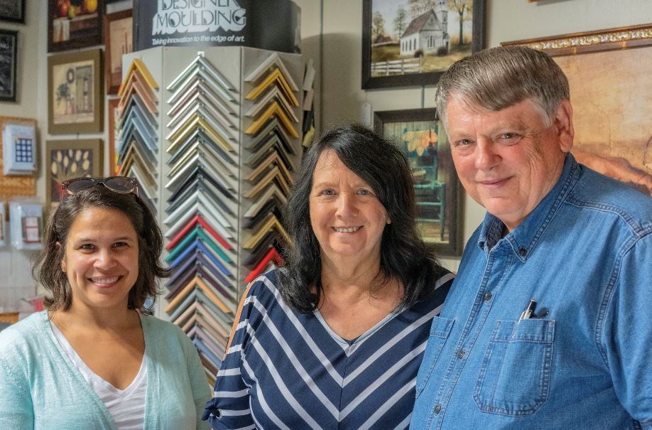 The business owners stand with MACED employee inside their framing business in Perry, County, Kentucky. MACED helped with their website