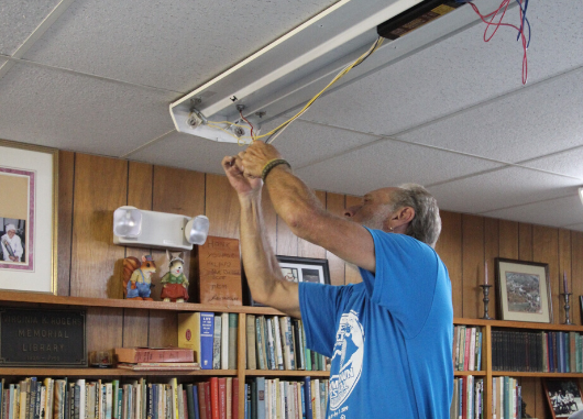 Person installs LED lighting for a nonprofit