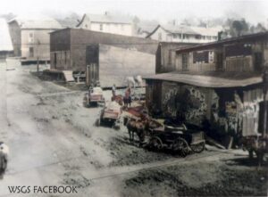 an old picture showing horses and wagons and old building