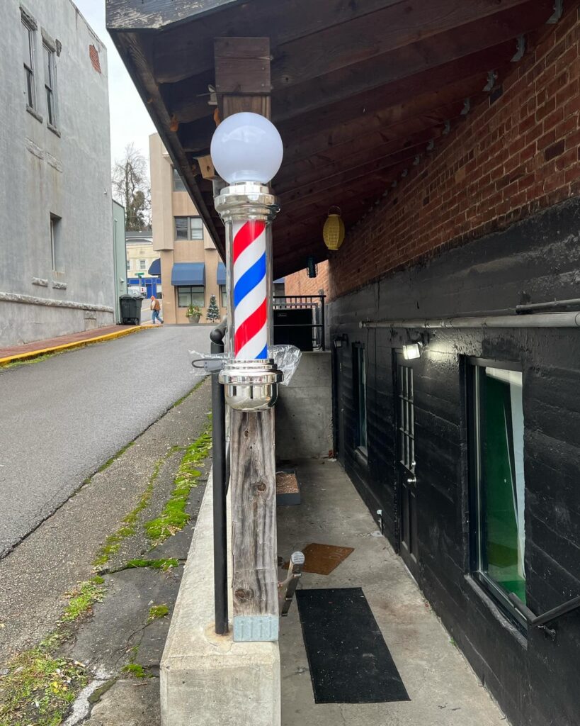 a classic blue,r ed and white barber pole is pictured off main street in downtown hazard kentucky