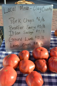 Tomatoes and a sign on a table in eastern kentucky at a farmers market.