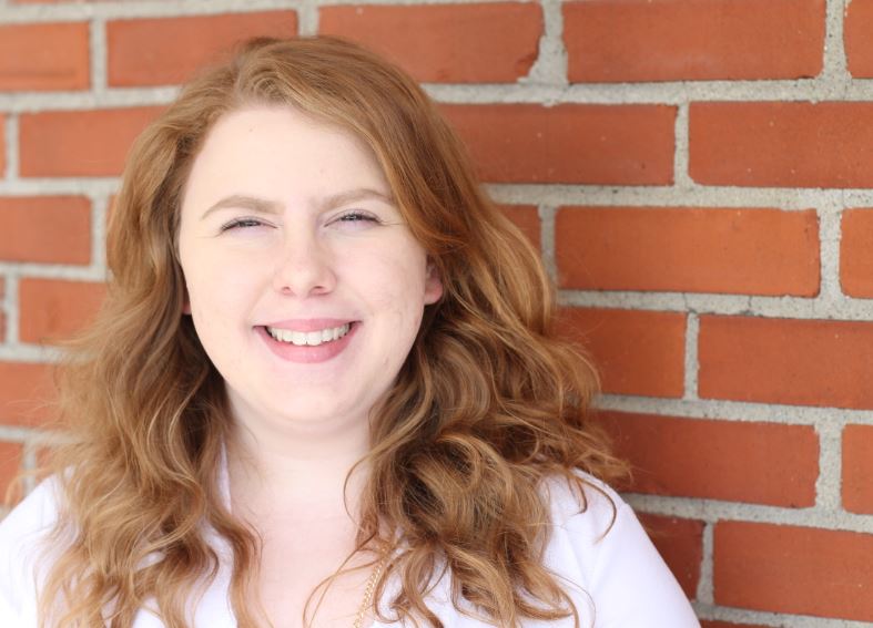 Megan Stepps smiles for her MACED New Energy internship portrait. She helped market the Appalachia Heat Squad in Eastern Kentucky.