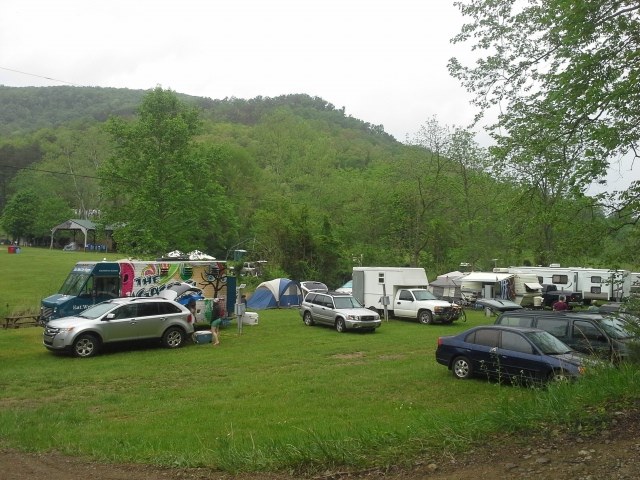 Several cars parked in a field at the base of a hill on Homegrown Hideaways property in Berea, KY.