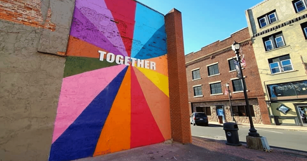 The word together is painted on a wall downtown Hazard in the middle of several colorful swatches.