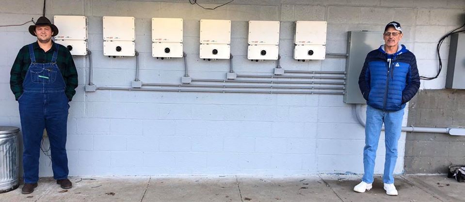 HOMES Inc. employees stand at Mountain Truck Parts in Letcher County after they completing the electrical work for the solar installation.