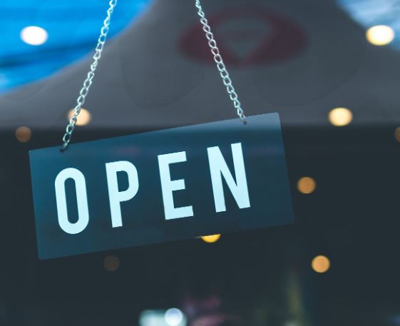 Open sign hangs in a door. MACED is offering economic recovery loans in Eastern Kentucky to help businesses during COVID-19.