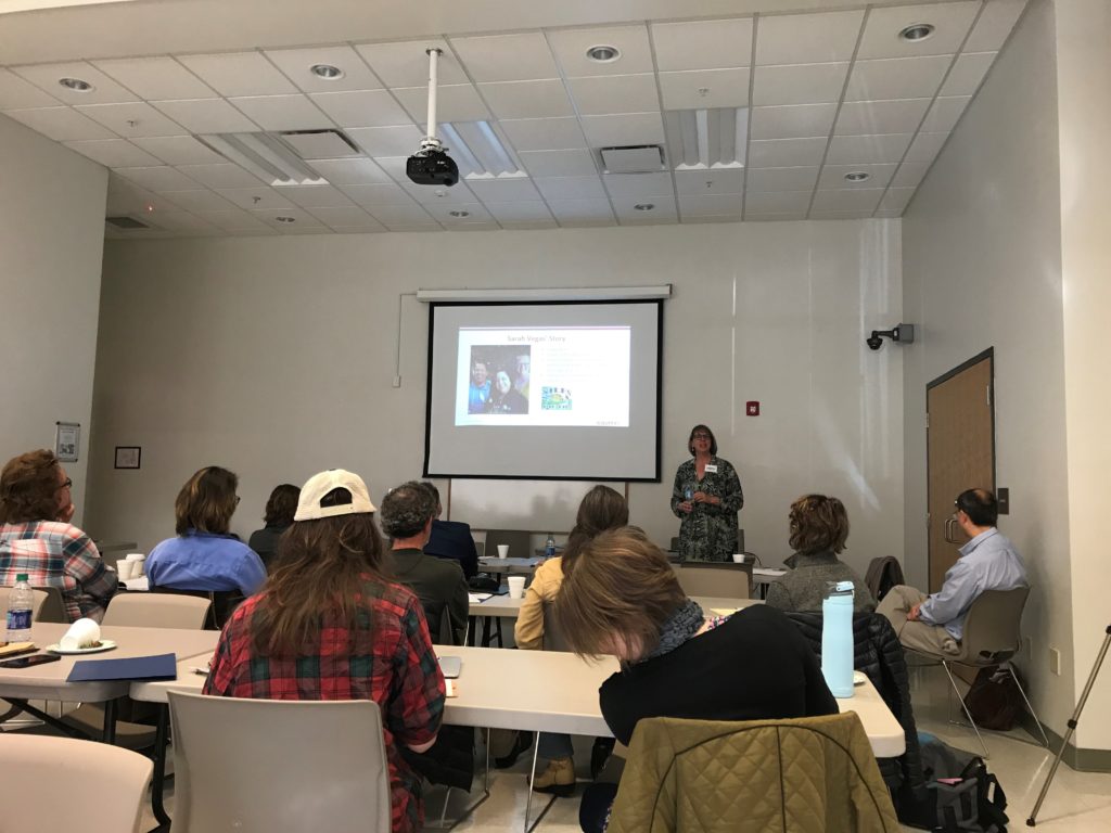 Several people sit in tables during a training at the perry county library in hazard, kentucky, about worker owned businesses.