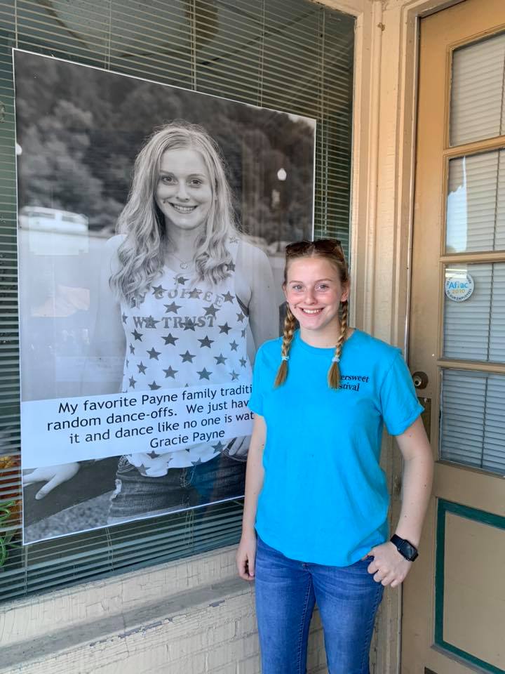A young resident stands with her Bittersweet Photos portrait on main street in Mount Vernon in East Kentucky's rockcastle county. 