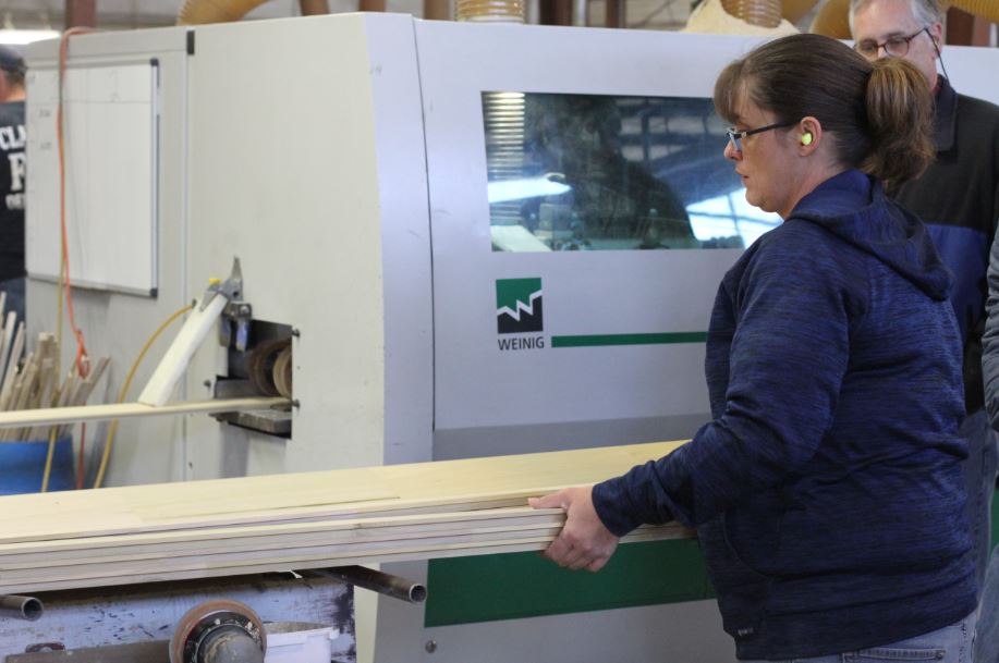 An employee at Powell Valley Millwork inspects a piece of wood. MACED provides business financing to the EKY family owned business