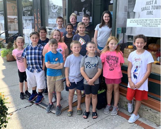 A group of kids stands on main street in front of Rockcastle Arts Association. The Mount Vernon nonprofit is supported by MACED