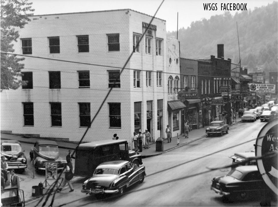 An old photo showing the building built in 1940 with old cars on the street.