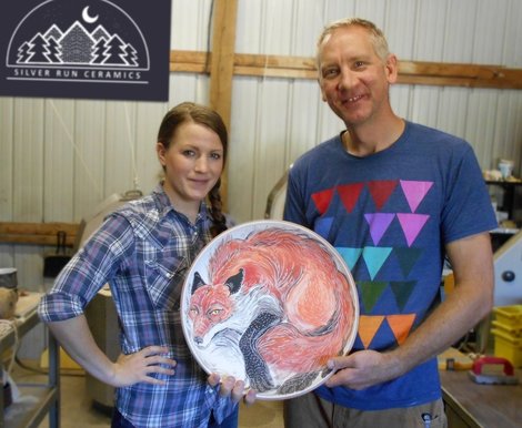The owners of Silver Run Ceramics in Catlettsburg KY in Eastern Kentucky stand in their studio with their ceramics. Their studio is now solar powered.