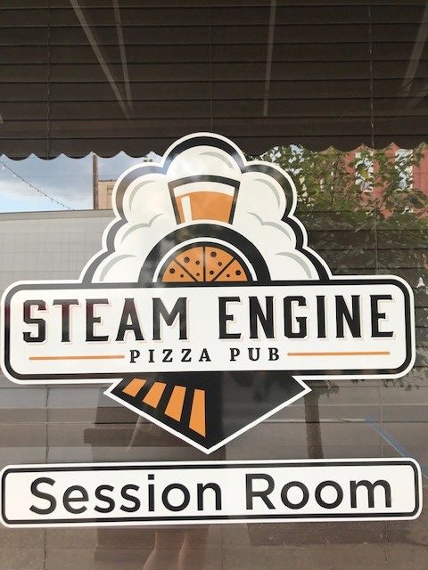 The window decal at the steam engine pizza pub in irvine, kentucky, a small town in estill county. The pub has live music.