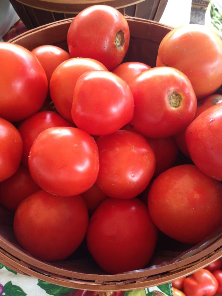 a bunch of tomatoes in a bowl at a farmers market in eastern kentucky. maced supports farmers with loans and energy assistance