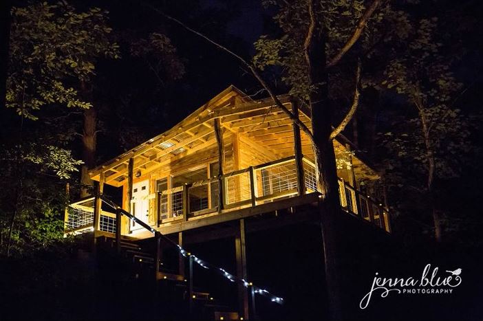 The treetop flyer, which is a treehouse, is lit up at night at homegrown hideaways in berea, kentucky.