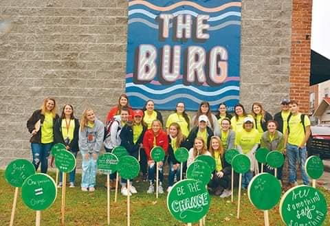 Group of Eastern Kentucky high schools with the Green Dot mural in downtown williamsburg. Mural aims to prevent domestic and sexual violence