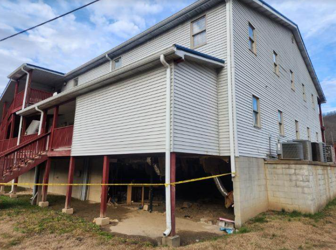 A picture of a building with caution tape around the foundation